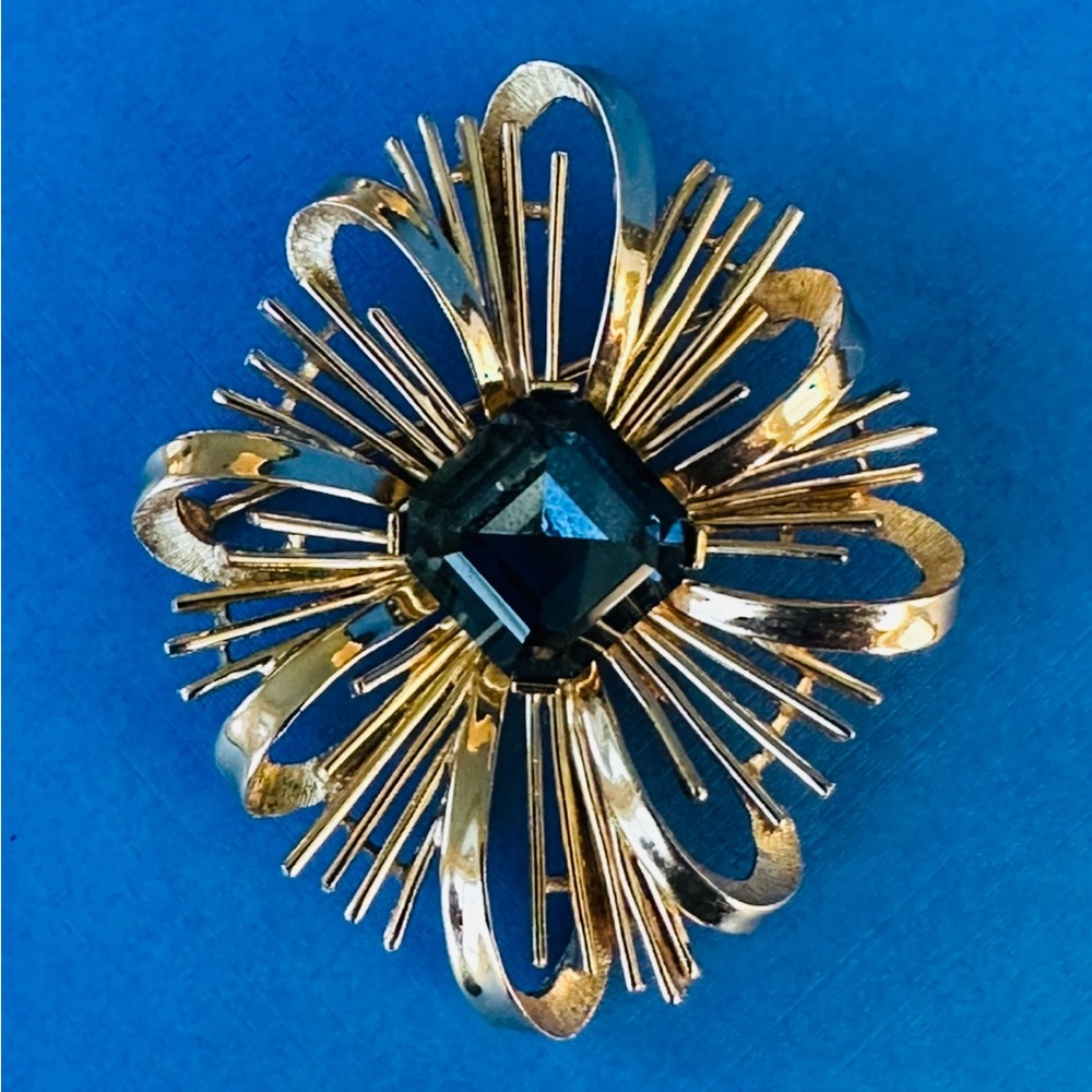 Crown Trifari Gold Tone Ribbon Starburst Brooch Sapphire Blue Rhinestone Center